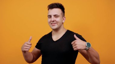 Charming young man pointing thumbs at himself, smiling.