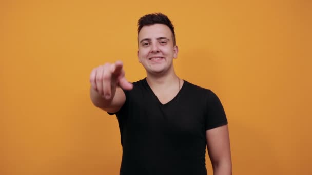 Guapo caucásico joven sonriendo, señalando el pulgar a la cámara . — Vídeos de Stock