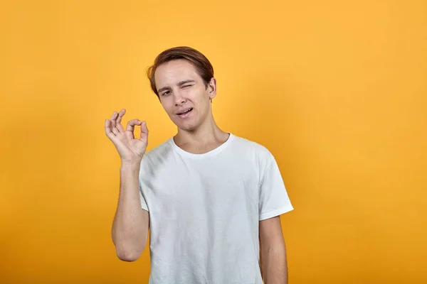 Man med vit t-shirt glad man stilig ansikte positiv hand gest — Stockfoto