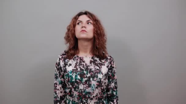 Потрясенная женщина, указывающая пальцами на открытый рот, выглядящая растерянной — стоковое видео