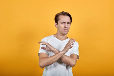 Beyaz gömlekli adam ellerini çapraz tutarak negatif jest yapmaya karşıdır.