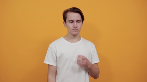 Mladý muž ukazuje svůj pupínek nebo černou hlavu přes lupu. — Stock video