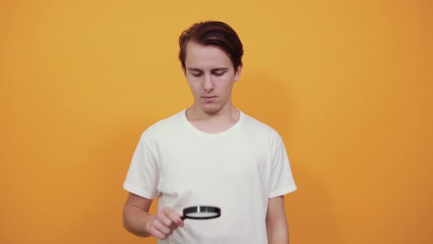 Smutný muž drží lupu blízko pupínku. — Stock video