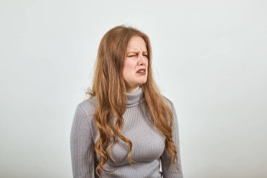 Gri kazaklı güzel kızıl saçlı bir kadın kötü ruh halinden hayal kırıklığına uğradı.