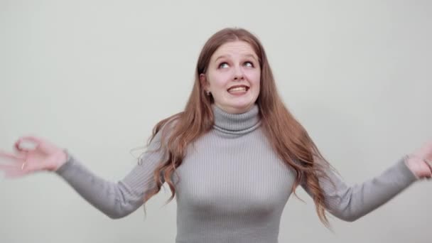 Nő szürke pulóver gesztikuláló kézzel érzelmek életmód. Szemhunyorítás. — Stock videók