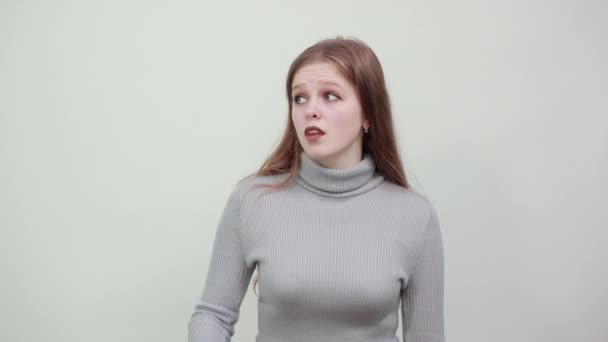 Frau mit roten Haaren im grauen Pullover versucht ihre Zähne mit Zahnbürste zu putzen — Stockvideo