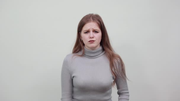 Vacker kvinna i grå tröja på bakgrunden har smärta i magen eller magen — Stockvideo