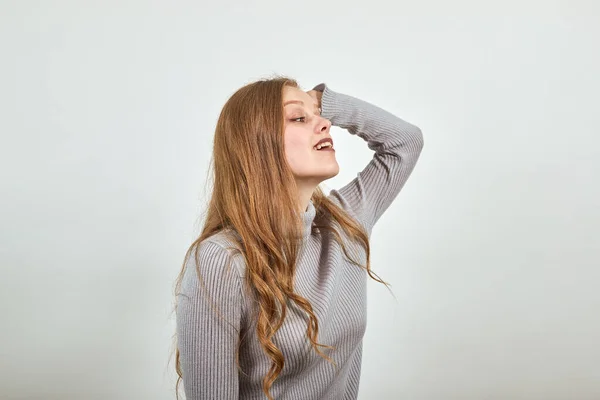 Une jeune belle femme aux cheveux rouges en pull gris pense donne naissance à une nouvelle idée — Photo