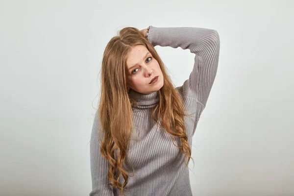 Donna dai capelli rossi in maglione grigio elegante sguardo fresco raddrizza i capelli con la mano — Foto Stock