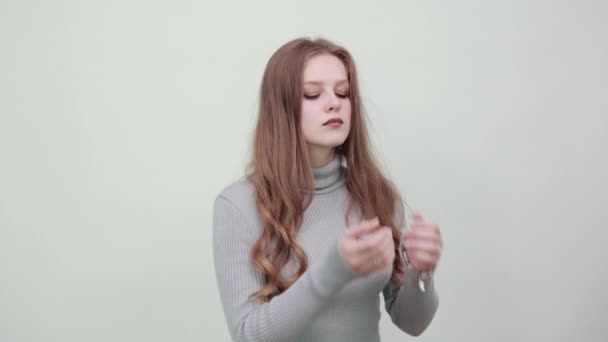 Woman in gray sweater adjusts her clothes the collar on it with confident look — Stock Video