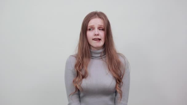 Gyönyörű vörös hajú nő szürke pulóverben nem magabiztosan látja, hogy oldalán — Stock videók