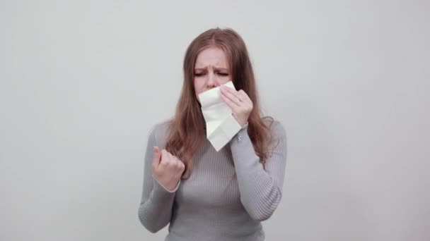 Krásná zrzavá žena v šedém svetru utírá nos s kapesníkem — Stock video