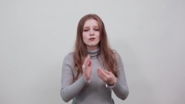 Gri kazaklı kızıl saçlı kadın diş ağrısı çekiyor.