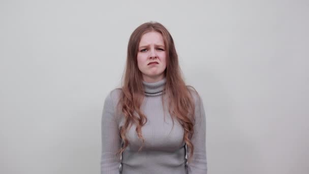 Una joven pelirroja hermosa en suéter gris pone sus pulgares abajo — Vídeos de Stock