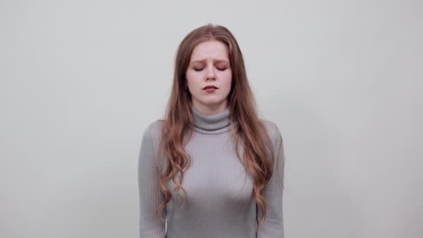 Руда волохата жінка в сірому светрі з головним болем тримає руки на голові — стокове відео