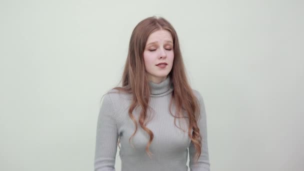 Vrouw in grijze trui toont vorm van hart met handen als teken van vriendelijkheid, genade — Stockvideo
