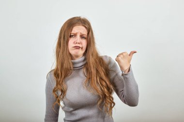 Gri kazaklı kadın memnun değil. Kızgın bir kız işaret ediyor.