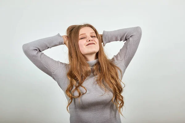 Женщина в сером свитере счастливое довольное лицо, держащее руки в восторге за голову — стоковое фото