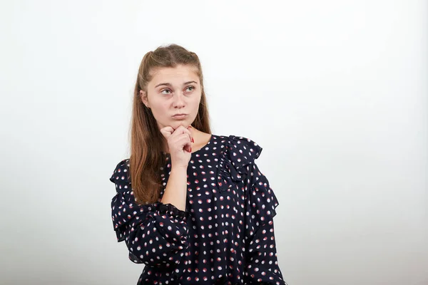 Mädchen im schwarzen Kleid denkt, trifft Entscheidung, hält ihr Kinn mit der Hand — Stockfoto