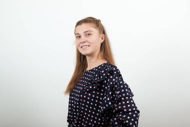 Beyaz daireli siyah elbiseli sarışın kız tam önümüzde duruyor.