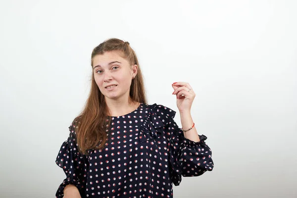 Chica en un vestido con círculos blancos posa con estilo para la cámara con gesto —  Fotos de Stock