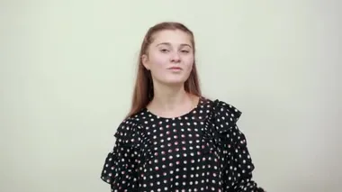 Beyaz daireli siyah elbiseli sarışın kız kollarını sallıyor.