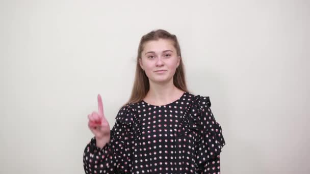 Hermosa chica de pelo rubio en vestido negro con círculos blancos muestra tres dedos — Vídeos de Stock