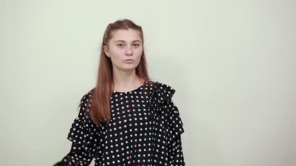 Flicka i en svart klänning med vita cirklar negativt humör postat tummen ner — Stockvideo