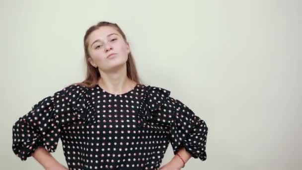Meisje in een zwarte jurk met witte cirkels ziet er stijlvol cool en poses — Stockvideo