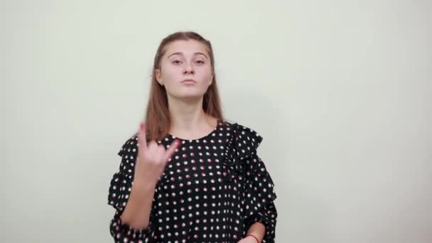 Lány fekete ruhában mutatja ujjai hűvös látszó szikla szimbólum — Stock videók