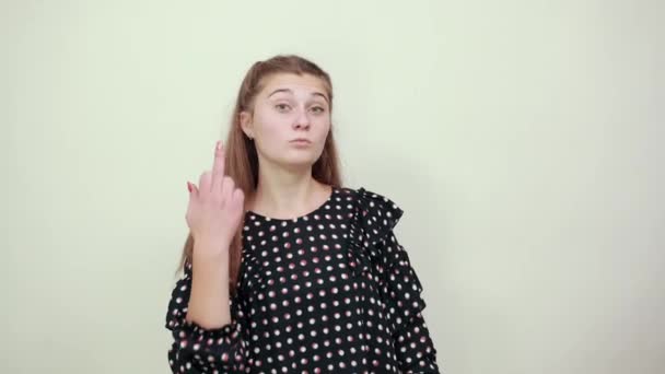 Chica en un vestido negro con círculos blancos nerviosa mujer enojada muestra el dedo medio — Vídeo de stock