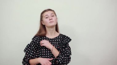 Beyaz daireli siyah elbiseli güzel kız kameraya poz veriyor..