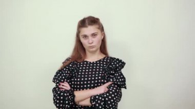 Siyah elbiseli kız sinirli bir ifade takınıp ellerini sımsıkı tutuyor.