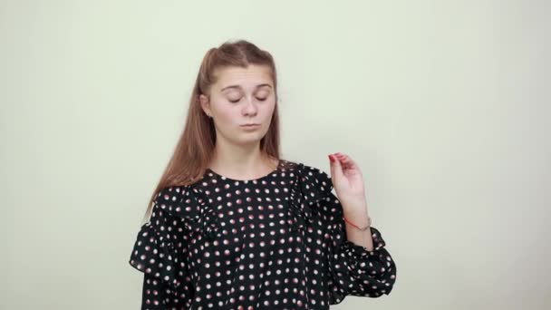 Lány egy ruha fehér körökben pózol stílusosan a kamera gesztussal — Stock videók