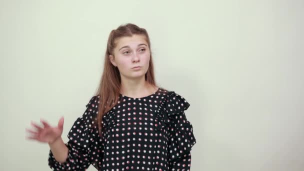 Mädchen im Kleid mit weißen Kreisen posiert stilvoll für die Kamera mit Geste — Stockvideo