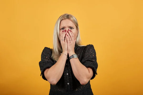 girl in black dress upset dissatisfied covered face with her hands from bad mood