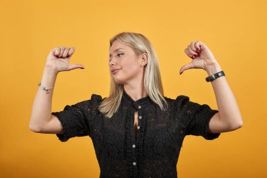 Sarı arka plandaki kız şık havalı kadın kendini işaret ediyor.