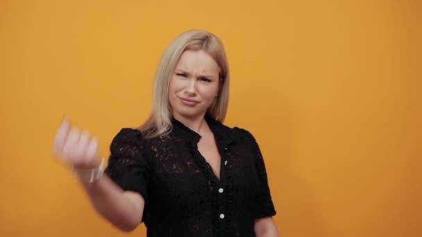 Meisje in zwart jurk op geel gelukkig vrouw is gelukkig gebald haar hand in vuist — Stockvideo