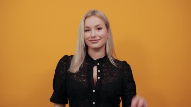 Chica en vestido negro sobre fondo amarillo mujer feliz muestra 2 dedos en las manos — Vídeos de Stock