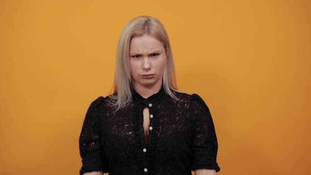 Meisje in zwart jurk op gele achtergrond geïrriteerde vrouw toont haar vuisten — Stockvideo