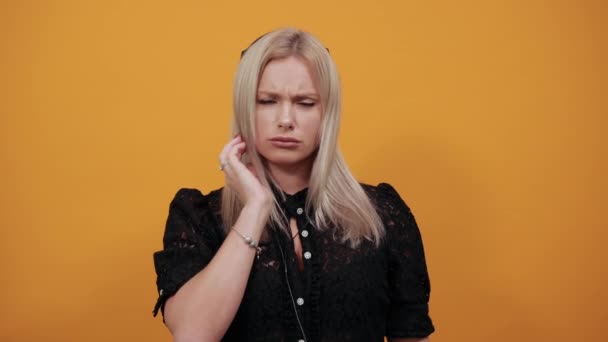 Αναστατωμένη γυναίκα ακούει μουσική σε ακουστικά με μια δυστυχισμένη έκφραση στο πρόσωπο — Αρχείο Βίντεο
