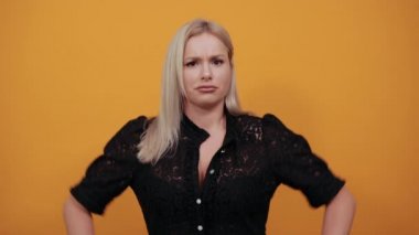 Sarı arka planda siyah elbiseli kız. Kararlı kadın kollarını sıvadı.