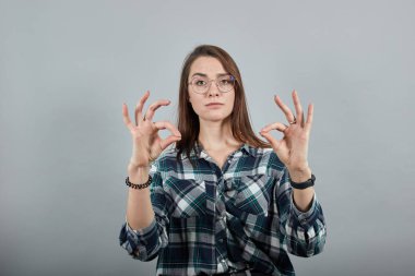 stylish woman in glasses folded her fingers in a sign OK, that she is all right