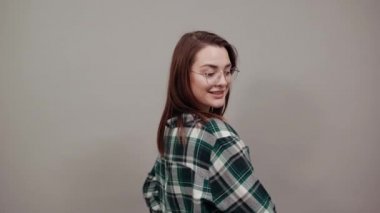 happy woman turned sideways smiles, demonstrates peleche