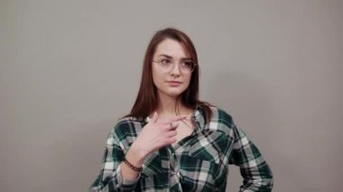 happy woman with glasses smiles, points at herself