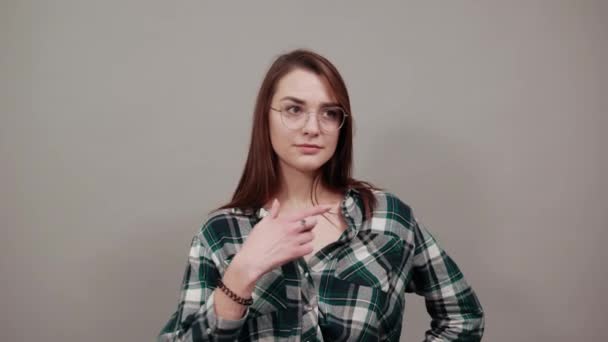 Glückliche Frau mit Brille lächelt, zeigt auf sich selbst — Stockvideo