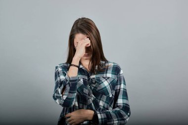 on grey background upset woman in glasses with bad mood