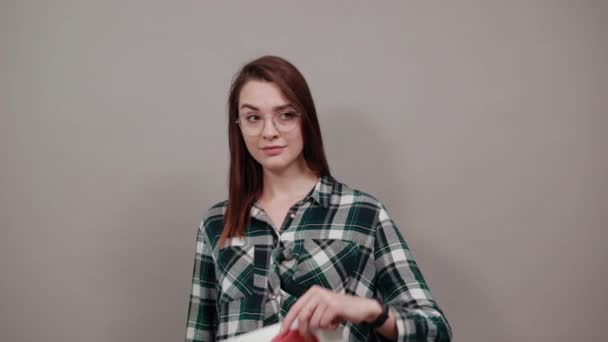 Happy woman with glasses holding a piece of paper with red heart, hand gestures — 비디오