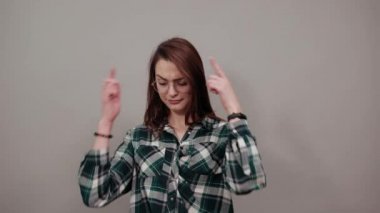 smart woman with glasses thinks, holds index fingers at temple of the head