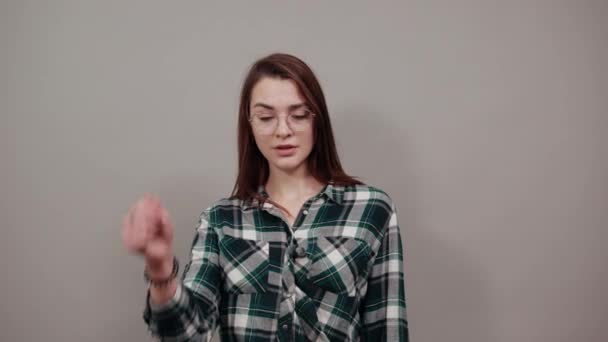 Gelukkig vrouw met bril toont haar index vinger — Stockvideo